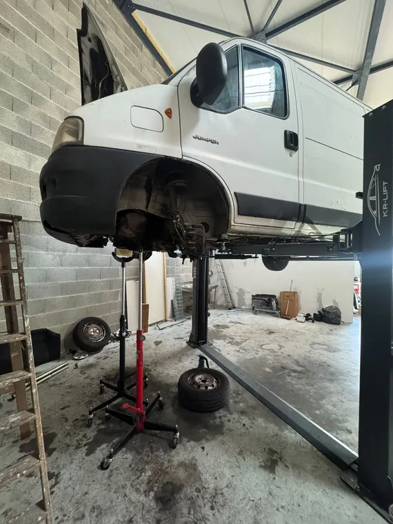 Utilitaire levé sur le pont élévateur de l'atelier MC Auto à Trévoux