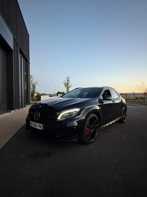 Compacte sportive Mercedes-AMG noire devant l'atelier MC Auto en fin de journée